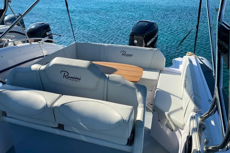  Yacht Photos Pics 2022 Ranieri CAYMAN 27.0 SPORT TOURING boat interior with seating and table on clear water.