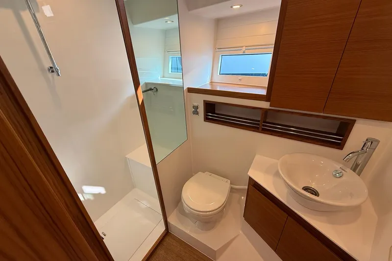  Yacht Photos Pics Modern bathroom interior of 2026 Delta Powerboats 48 Coupe, featuring sleek design and wooden accents.