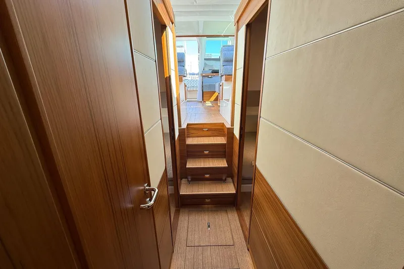  Yacht Photos Pics Interior hallway of 2026 Delta Powerboats 48 Coupe, featuring wooden paneling and stairs.