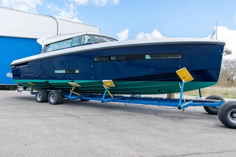  Yacht Photos Pics 2026 Delta Powerboats 48 Coupe on trailer, blue and green hull, outdoor setting.