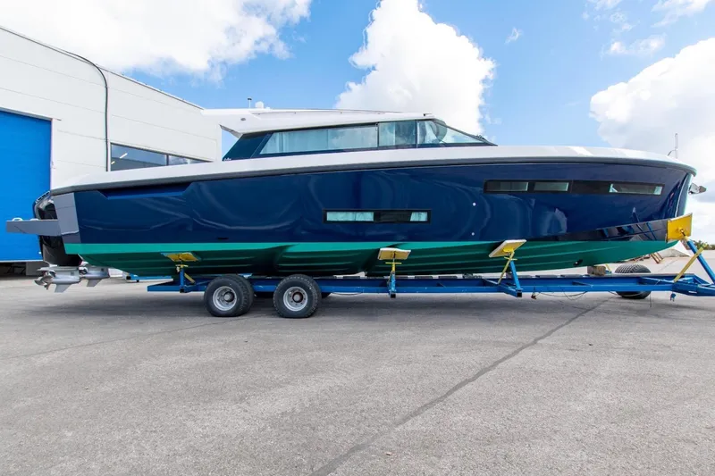  Yacht Photos Pics 2026 Delta Powerboats 48 Coupe on trailer, blue and green hull, dockside view.