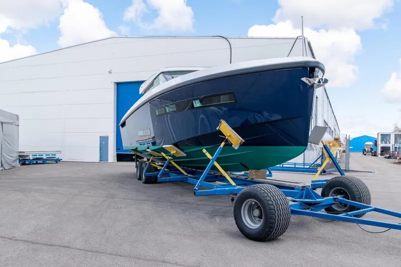  Yacht Photos Pics 2026 Delta Powerboats 48 Coupe on trailer outside a large warehouse.