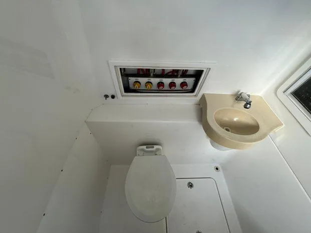 Killin Time II Yacht Photos Pics 2015 Invincible 39 Open Fisherman boat bathroom with toilet, sink, and control panel.