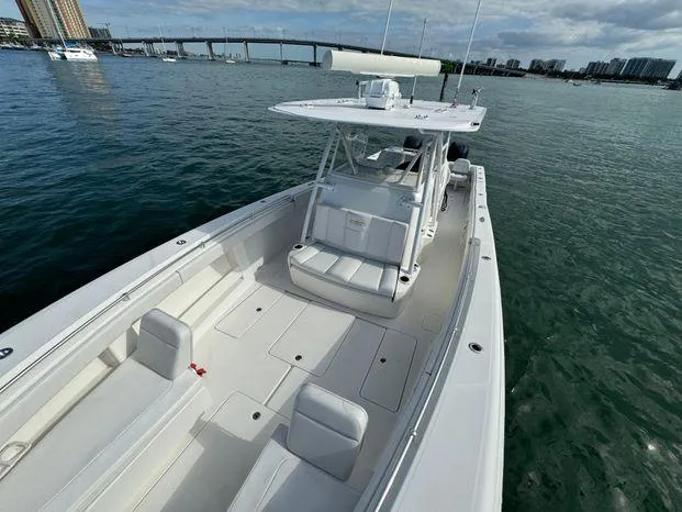 Killin Time II Yacht Photos Pics 2015 Invincible 39 Open Fisherman boat on calm water near a bridge and cityscape.