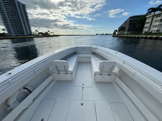 Killin Time II Yacht Photos Pics 2015 Invincible 39 Open Fisherman boat on calm water, urban skyline in background.