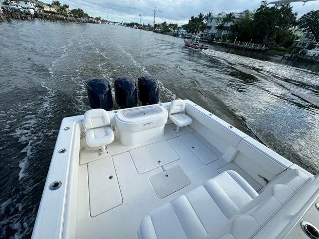 Killin Time II Yacht Photos Pics 2015 Invincible 39 Open Fisherman boat cruising on a waterway, featuring triple outboard engines.