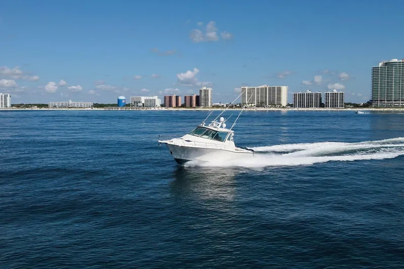 Papa's Dream Yacht Photos Pics 2016 Grady-White Express 370 cruising on ocean near city skyline.