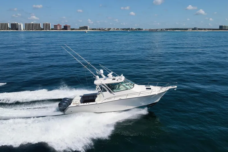 Papa's Dream Yacht Photos Pics 2016 Grady-White Express 370 cruising on open water, city skyline in background.