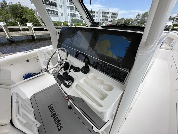 43 Everglades 435 Cc Yacht Photos Pics 2017 Everglades 435 Center Console boat cockpit with steering wheel and navigation screens.