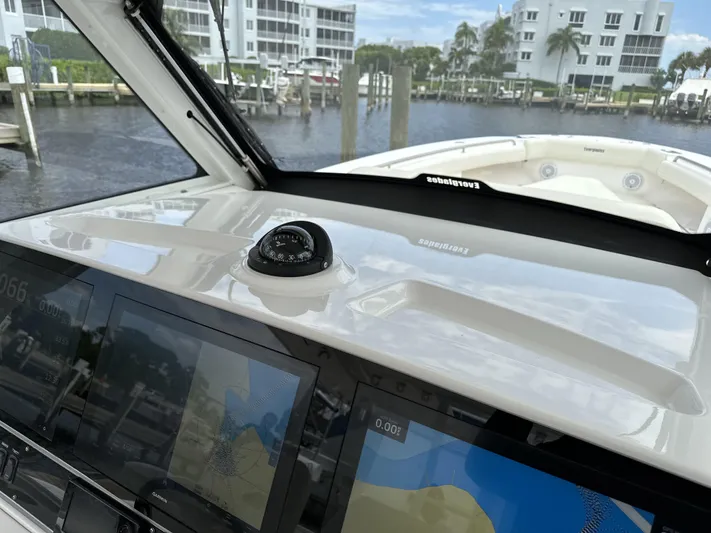 43 Everglades 435 Cc Yacht Photos Pics 2017 Everglades 435 Center Console boat dashboard with navigation screens, docked near waterfront buildings.