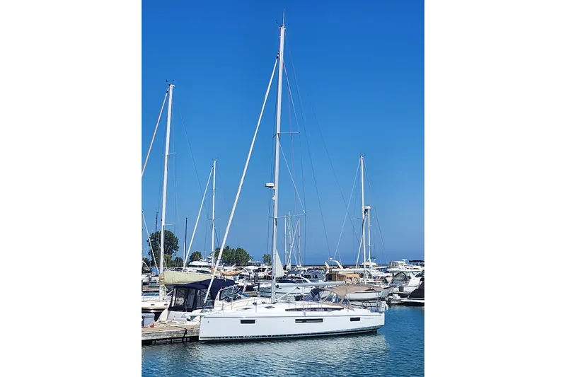 Rondeau Yacht Photos Pics 2020 Jeanneau Sun Odyssey 410 sailboat docked in a marina under clear blue skies.