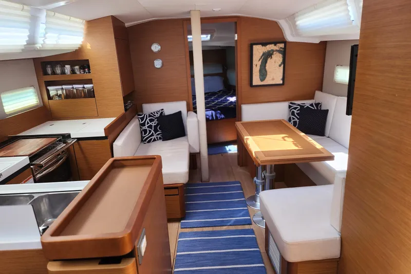 Rondeau Yacht Photos Pics Interior of 2020 Jeanneau Sun Odyssey 410 sailboat with modern wood finish and cozy seating.
