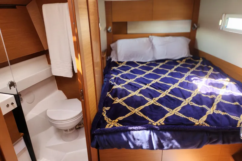 Rondeau Yacht Photos Pics Cozy cabin interior of 2020 Jeanneau Sun Odyssey 410 with bed and compact bathroom.