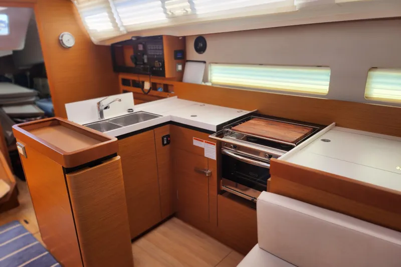 Rondeau Yacht Photos Pics Modern kitchen interior of 2020 Jeanneau Sun Odyssey 410 yacht, featuring sleek wood finishes.