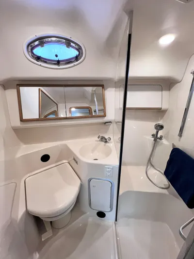 Rising Tide Yacht Photos Pics 1996 Sea Ray 400 Sedan Bridge bathroom with shower, sink, and porthole window.