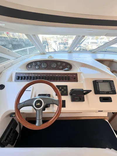 Rising Tide Yacht Photos Pics 1996 Sea Ray 400 Sedan Bridge helm with wooden steering wheel and navigation instruments.