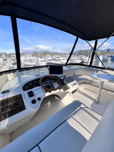 Rising Tide Yacht Photos Pics 1996 Sea Ray 400 Sedan Bridge yacht cockpit with steering wheel, dashboard, and marina view.