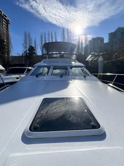 Rising Tide Yacht Photos Pics 1996 Sea Ray 400 Sedan Bridge yacht under sunny sky with cityscape background.