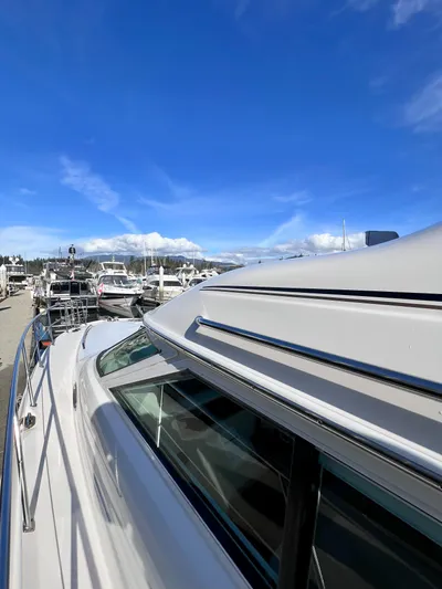 Rising Tide Yacht Photos Pics 1996 Sea Ray 400 Sedan Bridge yacht docked under a clear blue sky.