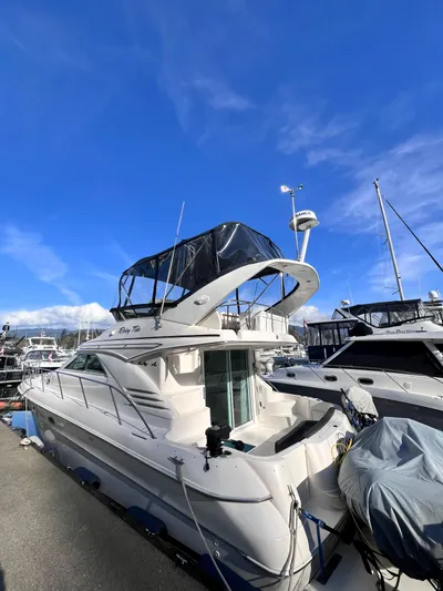 Rising Tide Yacht Photos Pics 1996 Sea Ray 400 Sedan Bridge yacht docked under clear blue sky.