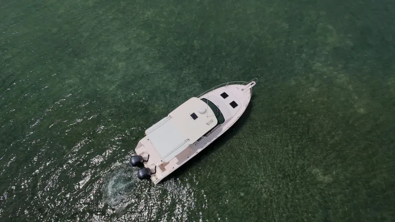  Yacht Photos Pics Aerial view of 2013 Grady-White Express 330 boat on calm green water.