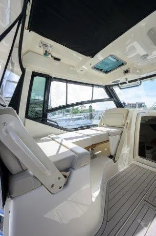 325 Boston Whaler W/ Seakeeper Stabilizer & Ride Yacht Photos Pics 2020 Boston Whaler 325 Conquest interior with seating and windows, showcasing luxury and comfort.