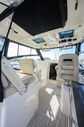 325 Boston Whaler W/ Seakeeper Stabilizer & Ride Yacht Photos Pics Interior of 2020 Boston Whaler 325 Conquest boat, featuring modern seating and navigation equipment.