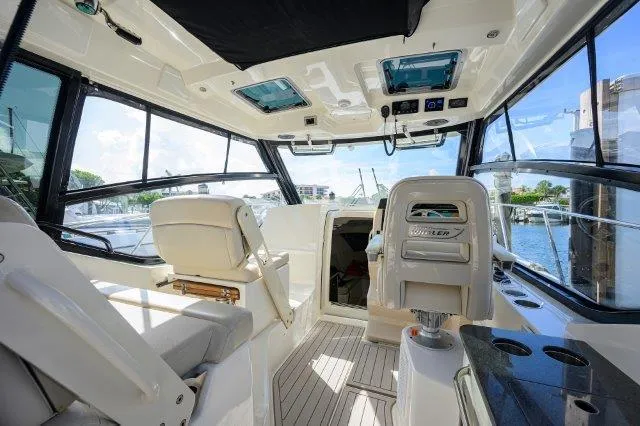 325 Boston Whaler W/ Seakeeper Stabilizer & Ride Yacht Photos Pics 2020 Boston Whaler 325 Conquest interior, featuring helm seats and panoramic windows.