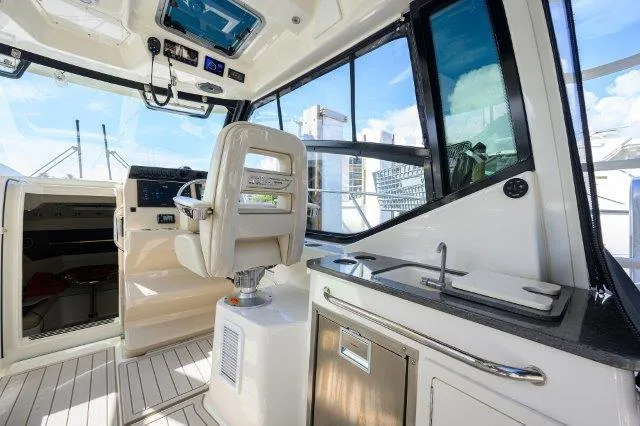 325 Boston Whaler W/ Seakeeper Stabilizer & Ride Yacht Photos Pics Interior of 2020 Boston Whaler 325 Conquest boat, featuring helm and kitchenette.