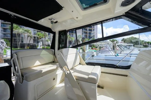 325 Boston Whaler W/ Seakeeper Stabilizer & Ride Yacht Photos Pics Interior of 2020 Boston Whaler 325 Conquest boat with seating and marina view.