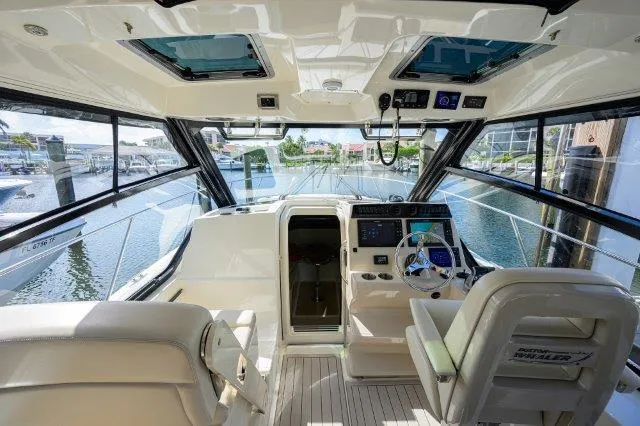 325 Boston Whaler W/ Seakeeper Stabilizer & Ride Yacht Photos Pics Interior view of 2020 Boston Whaler 325 Conquest boat, featuring helm and seating area.