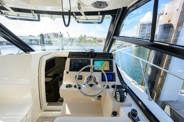 325 Boston Whaler W/ Seakeeper Stabilizer & Ride Yacht Photos Pics 2020 Boston Whaler 325 Conquest helm with modern navigation system and waterfront view.