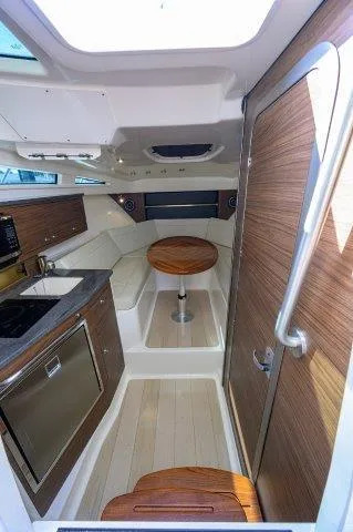 325 Boston Whaler W/ Seakeeper Stabilizer & Ride Yacht Photos Pics 2020 Boston Whaler 325 Conquest cabin interior with kitchenette and seating area.