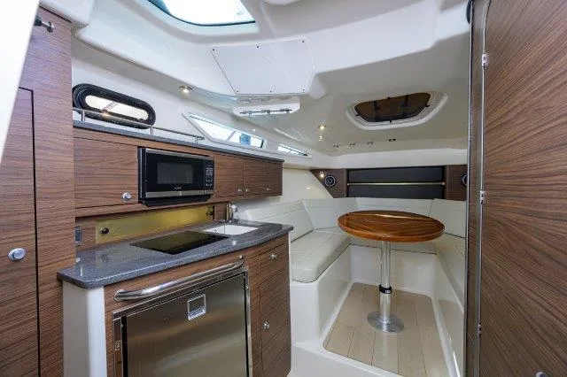 325 Boston Whaler W/ Seakeeper Stabilizer & Ride Yacht Photos Pics 2020 Boston Whaler 325 Conquest interior with kitchenette and seating area.