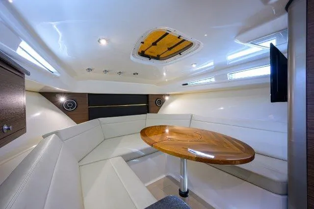 325 Boston Whaler W/ Seakeeper Stabilizer & Ride Yacht Photos Pics 2020 Boston Whaler 325 Conquest cabin interior with seating and wooden table.