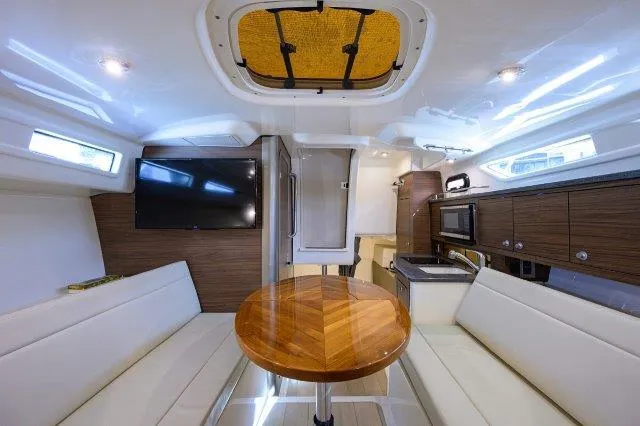 325 Boston Whaler W/ Seakeeper Stabilizer & Ride Yacht Photos Pics Interior of 2020 Boston Whaler 325 Conquest, featuring modern seating, table, and kitchenette.