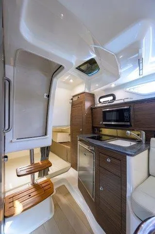 325 Boston Whaler W/ Seakeeper Stabilizer & Ride Yacht Photos Pics 2020 Boston Whaler 325 Conquest cabin interior with modern kitchen and seating area.