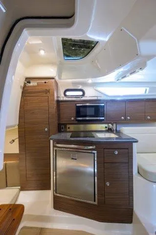 325 Boston Whaler W/ Seakeeper Stabilizer & Ride Yacht Photos Pics 2020 Boston Whaler 325 Conquest cabin with modern kitchen and wood accents.