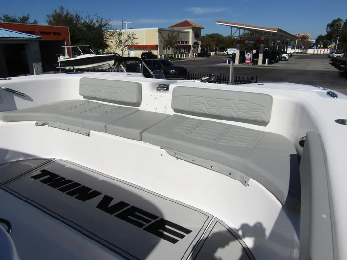  Yacht Photos Pics 2023 Twin Vee 340 GFX CC boat interior with cushioned seating in a marina setting.