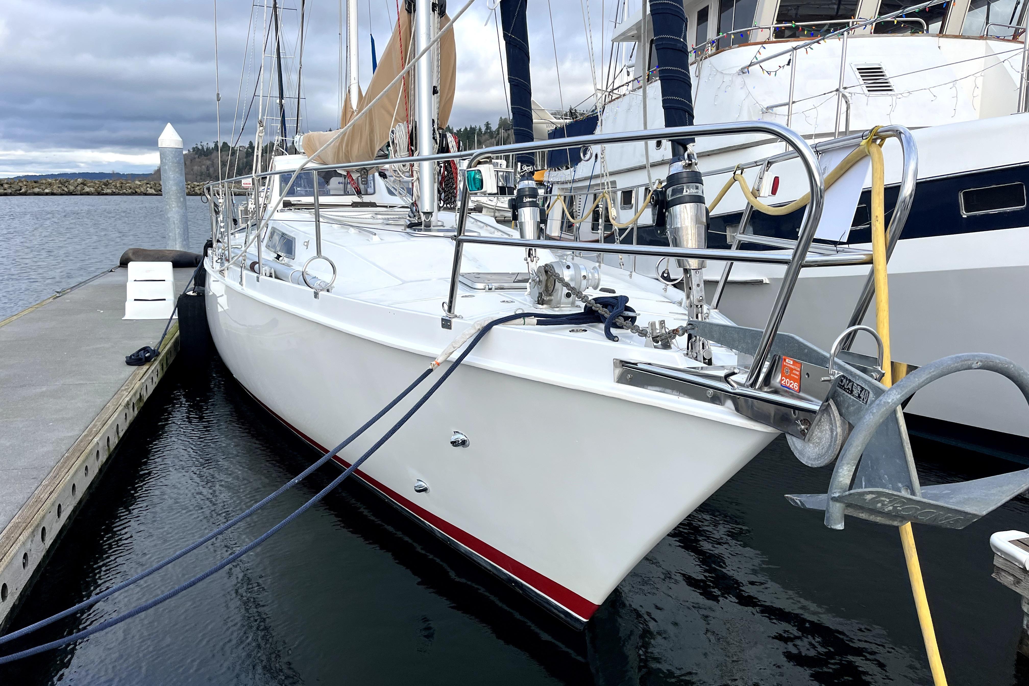 1979 Amel Mango sailboat docked at marina, featuring sleek white hull and nautical equipment.