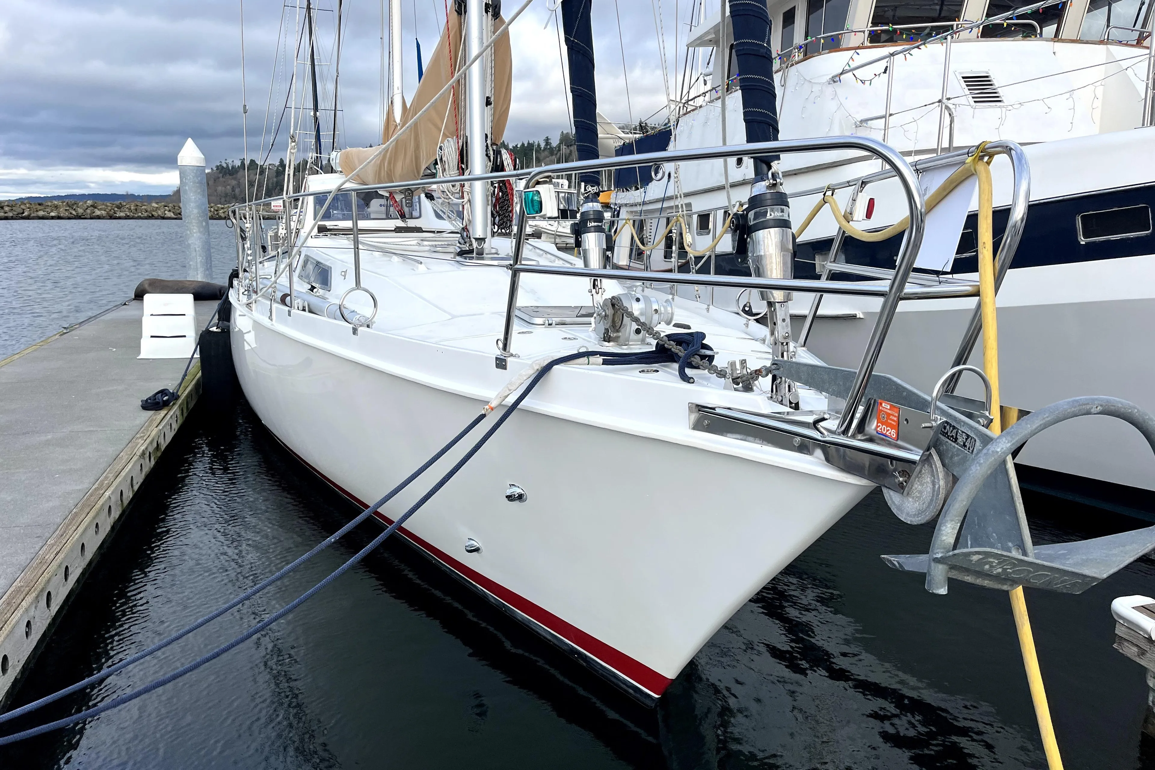 1979 Amel Mango sailboat docked at marina, featuring sleek white hull and nautical equipment.