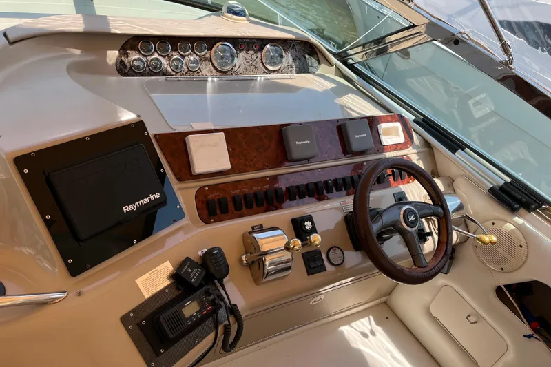  Yacht Photos Pics 1998 Sea Ray 450 Sundancer helm with steering wheel, gauges, and navigation equipment.