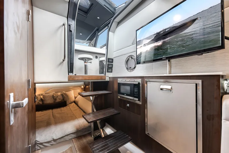  Yacht Photos Pics 2023 Cruisers Yachts 42 GLS OB interior with bed, TV, and kitchenette.