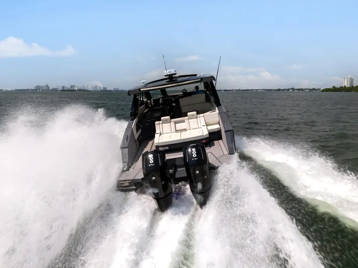  Yacht Photos Pics 2023 Cruisers Yachts 42 GLS OB speeding on open water, rear view.