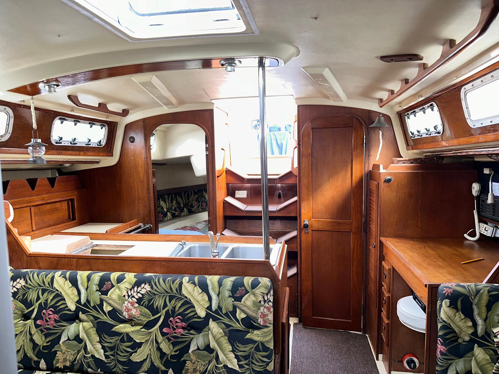Interior of a 1987 Pearson 36-2 sailboat with wood finish and floral upholstery.