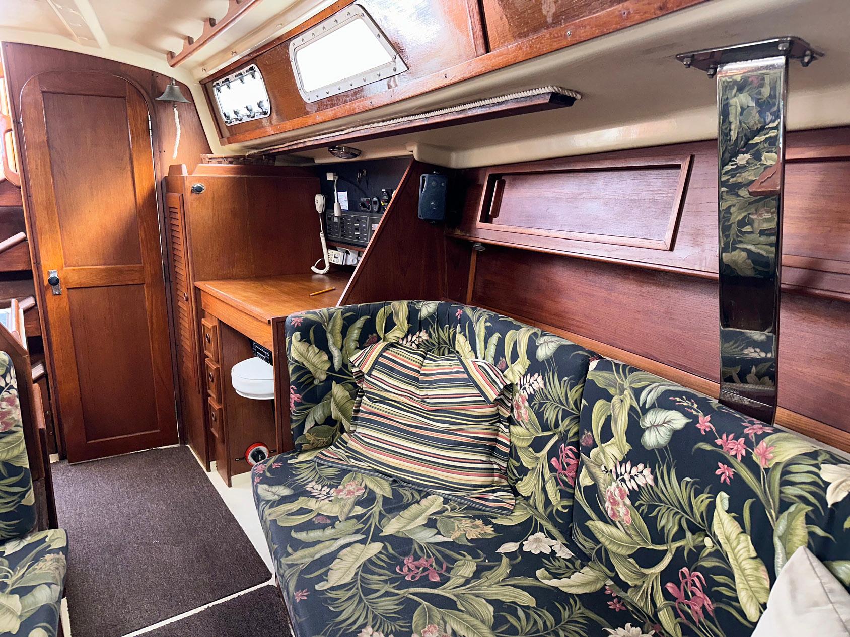 Interior of 1987 Pearson 36-2 sailboat with floral upholstery and wooden cabinetry.