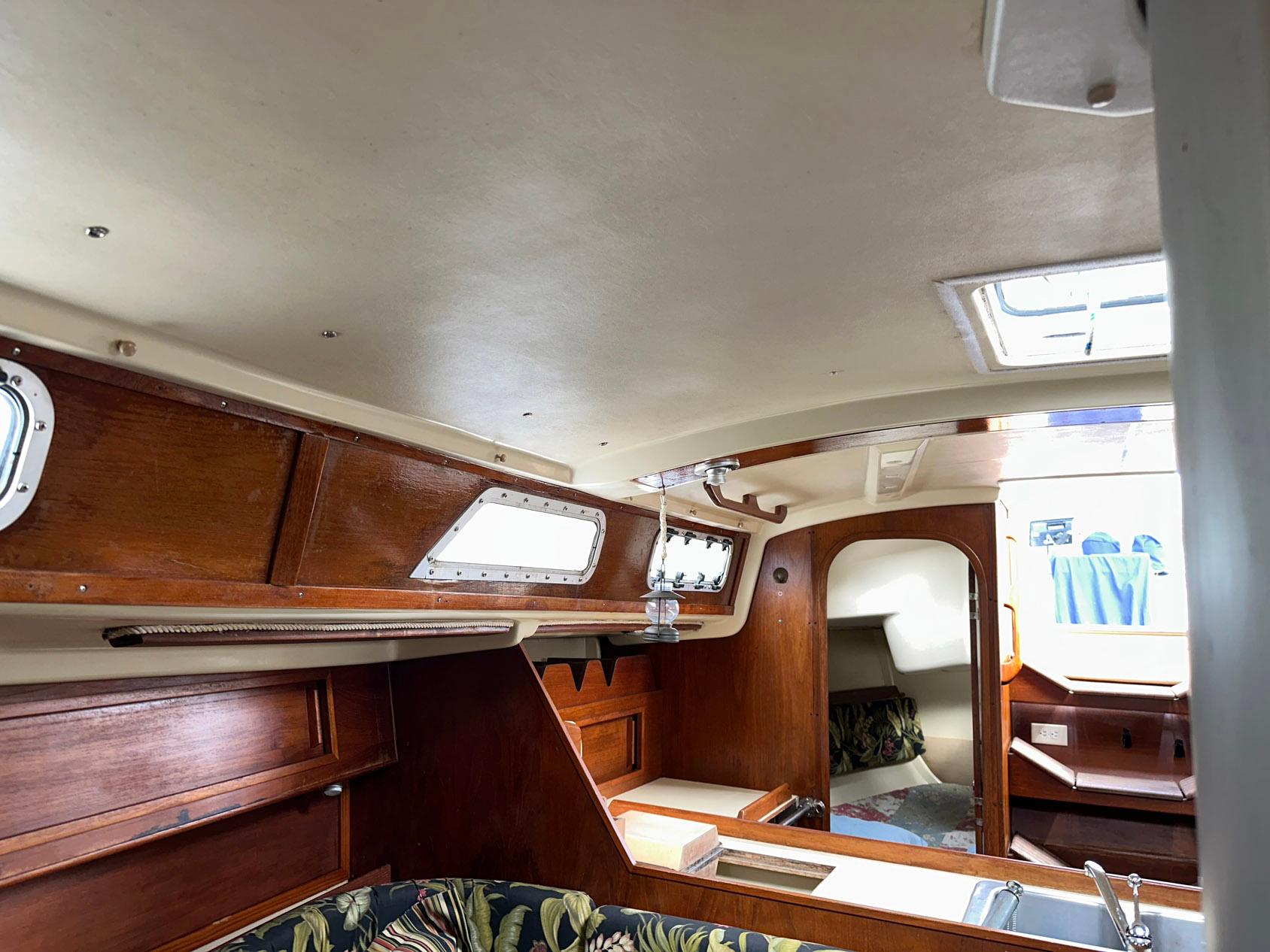 Interior of 1987 Pearson 36-2 sailboat with wooden cabinetry and seating area.