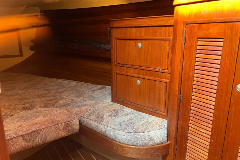 Starlight Yacht Photos Pics 1995 Island Packet 37 sailboat interior with wooden cabinetry and cushioned berth.