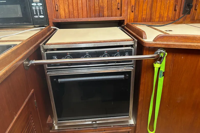 Starlight Yacht Photos Pics 1995 Island Packet 37 yacht kitchen with stove and wooden cabinetry.