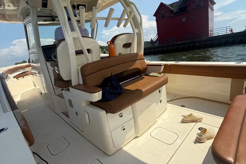  Yacht Photos Pics 2016 Scout 350 LXF boat interior with brown seating, docked near a red building.